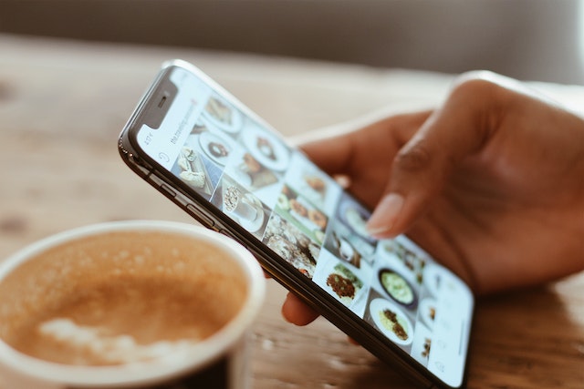 Social Media smartphone in der hand auf einem Holztisch liegend